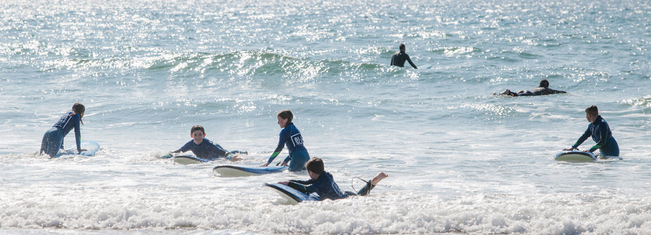 Boy learning to surf with Blue Surf School